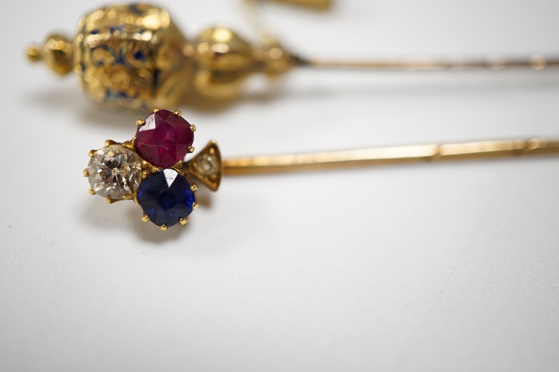 An early 20th century Viennese yellow metal, ruby, diamond and sapphire set 'clover' stick pin, 68mm, together with a yellow metal and blue enamel set stick pin.
